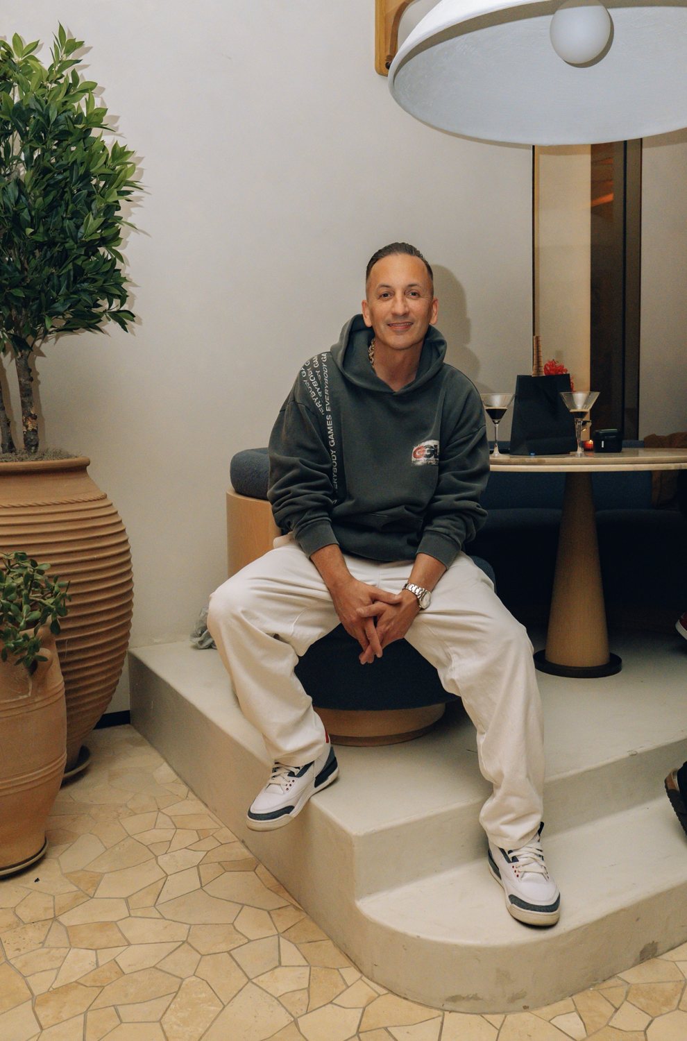 Clinton Sparks in a GGL hoodie, seated on a step